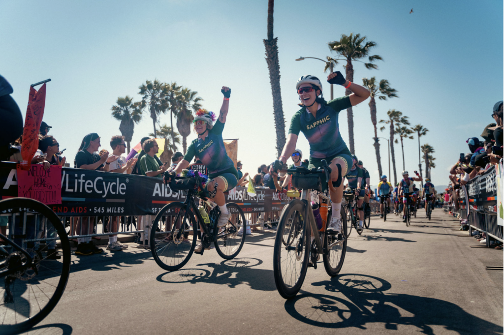people riding on bicycles into the finish line of a fundraiser ride
