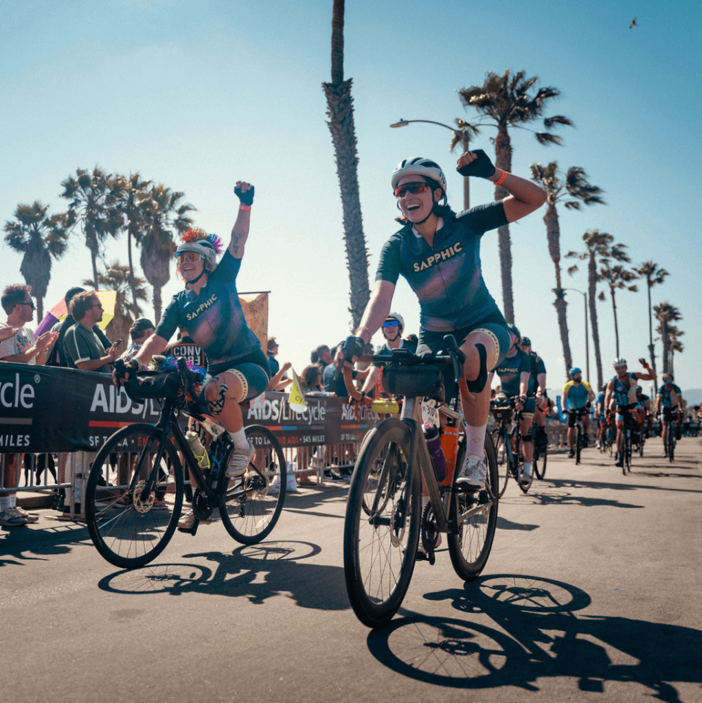 people riding on bicycles into the finish line of a fundraiser ride